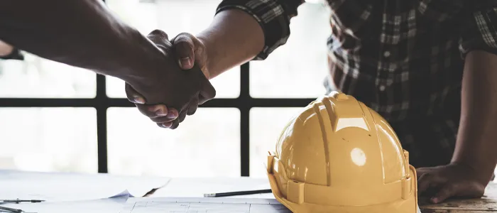 contractor and stakeholder shaking hands after a construction estimate review